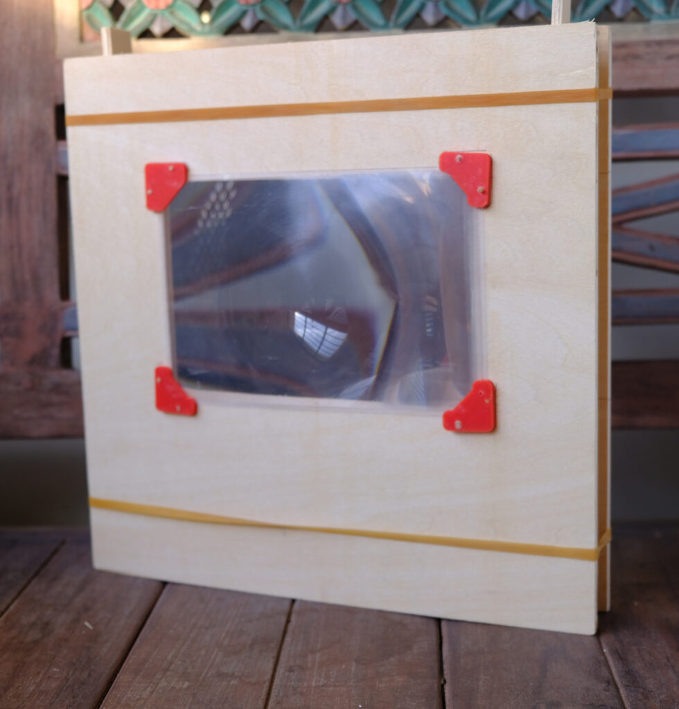 Fresnel lens separated by a narrow strip of plywood 